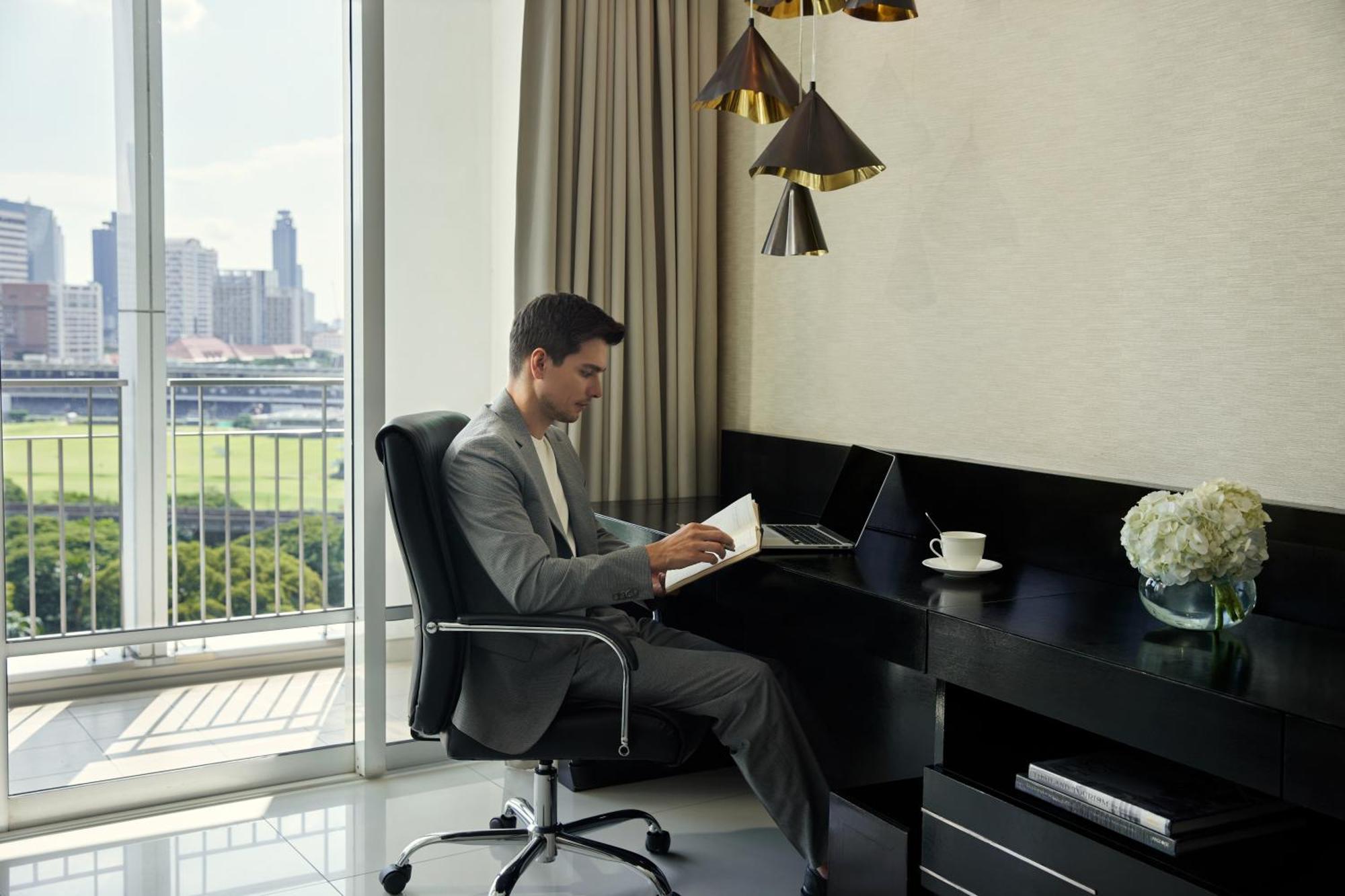 Dusit Suites Hotel Ratchadamri, Bangkok Eksteriør billede A man working at a desk